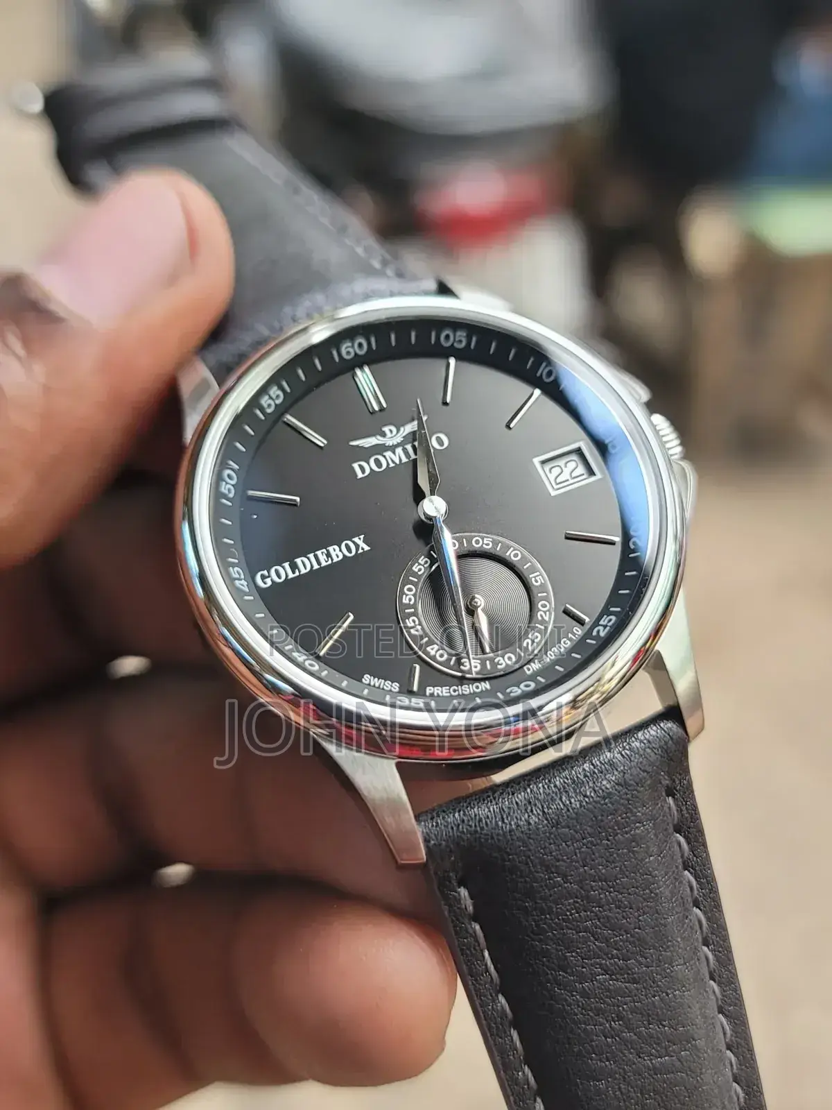 Domino Men's Watch With a Silver Case and a Black Leather Band.