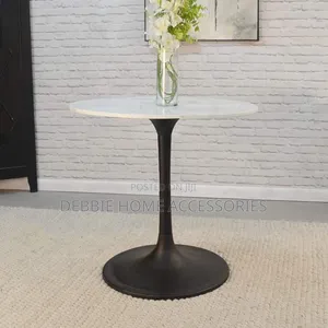 Round Dining Table With a White Marble Top and a Black Base.