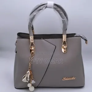 Grey Handbag With Gold Accents and a Keychain