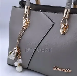 Grey Handbag With Gold Accents and a Keychain